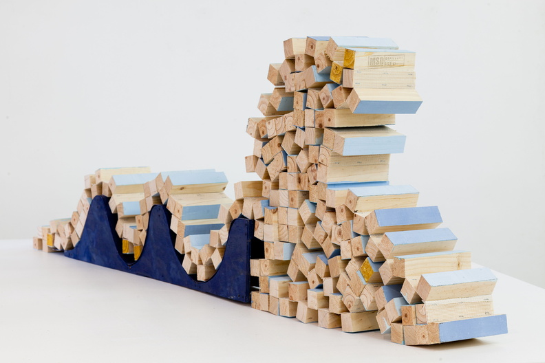 La escultura es un modelo que revisa la caída de una ola como un desmoronamiento en cadena. / Tira de tela unida a trozos de madera que se apilan de manera aleatoria una sobre otra.
6_Fca.Sanchez.jpg